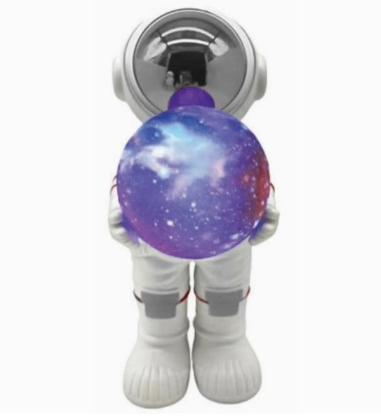 The Fahionit Astronaut Wireless Speaker features a toy astronaut in a white suit holding a balloon adorned with a mesmerizing galaxy pattern—complete with stars and nebulae—reflected in its shiny helmet, making it an enchanting addition to any space enthusiast’s collection or playful astronaut-themed decor.