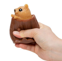 A hand squeezes the Nutty Squirrel Popper by Schylling Toys, a brown stress relief fidget toy shaped like a tree stump with an adorable squirrel popping out of the top—making it a delightful sensory toy for unwinding moments.