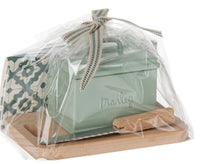 The Maileg Bread Box W. Utensils, Miniature by Maileg—featuring a green tin box and utensils—is a charming furniture accent for your Maileg Mouse, neatly wrapped in clear plastic with a ribbon on top.