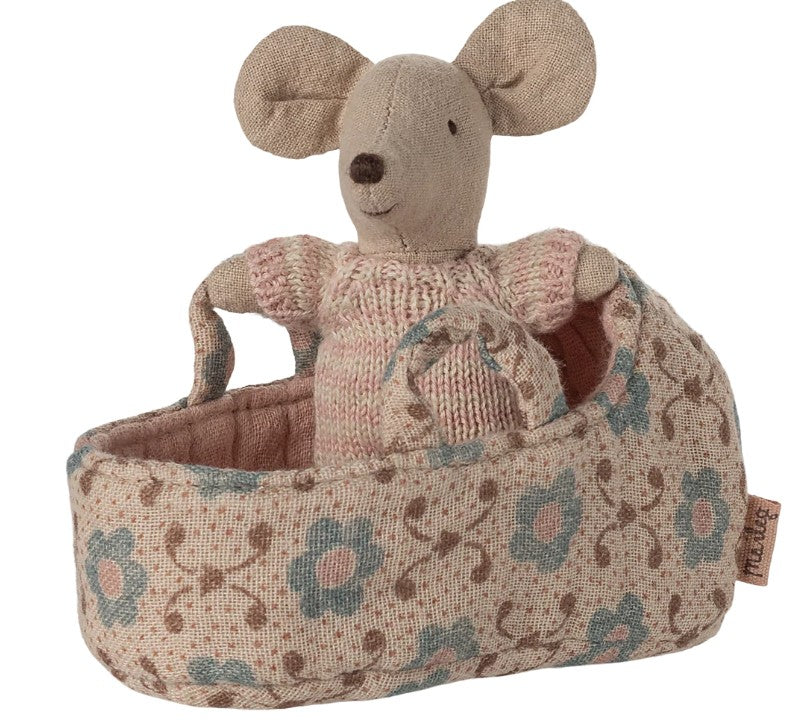 The Maileg Baby Mouse in Carry Cot - Rose features a Maileg baby mouse dressed in a pink sweater, nestled in a soft floral carry cot—ideal for gentle adventures and nurturing play.