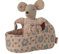 The Maileg Baby Mouse in Carry Cot - Rose features a Maileg baby mouse dressed in a pink sweater, nestled in a soft floral carry cot—ideal for gentle adventures and nurturing play.
