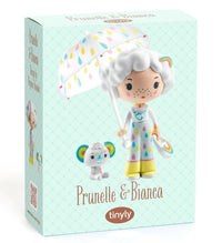 Discover the DJECO Tinyly Prunelle & Blanca toy box from DJECO, featuring collectible figurines of Prunelle—a girl with white hair in a raincoat holding an umbrella—and her small companion, Blanca. The light blue box showcases a charming diamond pattern, making it the perfect collectible set for fans of Tinyly miniature figures.