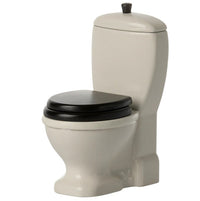 The Maileg Toilet, Mouse by Maileg is a small white dollhouse miniature with black seat and lid, plus a rounded tank and base—ideal furniture for mouse-sized play. Set on a plain white background.