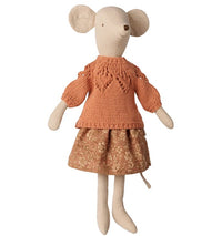 A Maileg medium mouse, dressed in the Maileg Skirt and Knitted Sweater outfit—featuring an orange knit sweater and a brown patterned skirt—stands upright against a white background, inviting imaginative storytelling.