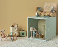 Maileg Grandma and Grandpa Mice in Cigarbox by Maileg features the mouse duo cozy in their decorated box room, sitting at a table with tea, surrounded by charming details for imaginative play.