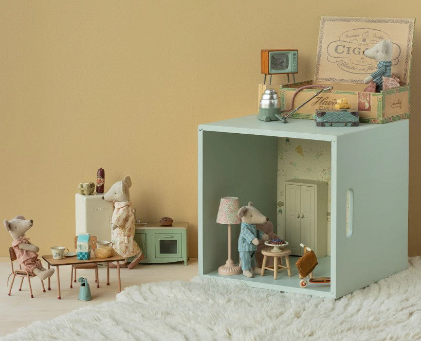 Maileg Grandma and Grandpa Mice in Cigarbox by Maileg features the mouse duo cozy in their decorated box room, sitting at a table with tea, surrounded by charming details for imaginative play.