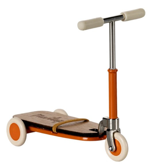 The Maileg Kick board, Mouse - Orange by Maileg is a small, vintage-style toy scooter featuring three white wheels, an orange frame, and beige handlebars. Designed for pretend play with Maileg mice, this miniature kick board includes a wooden deck and a thin strap across the center.