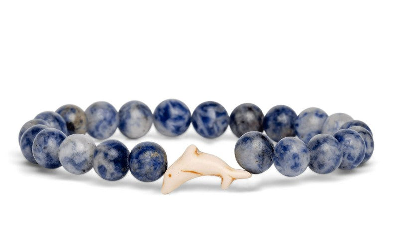 The fahlo Odyssey - Coastal Blue Dolphin bracelet features round blue marbled stones and a central white dolphin charm—an ideal accessory for marine conservation enthusiasts.