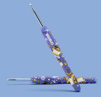 Two blue-handled crochet hooks, featuring cartoon animals, snowflakes, and "WOOBLES," are shown on a light blue background—perfect for beginners using The Woobles Claire the Angel Crochet Kit.