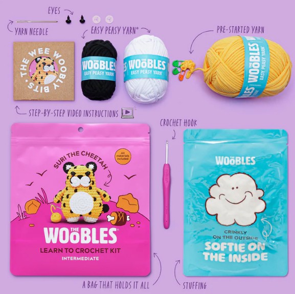 The Suri the Cheetah Crochet Kit by The Woobles includes yarn, a crochet hook, eyes, stuffing, needle, step-by-step instructions, and a cute resealable bag marked “Learn to Crochet Kit.” Perfect for beginners!.