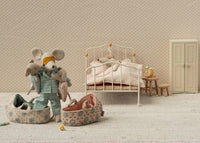 Create a nurturing play scene with the Maileg Baby Mouse In Carry Cot - Rose by Maileg, featuring an adult mouse in pajamas with two Baby Mice, as another mouse rests in bed near a nightstand, clock, and wardrobe.