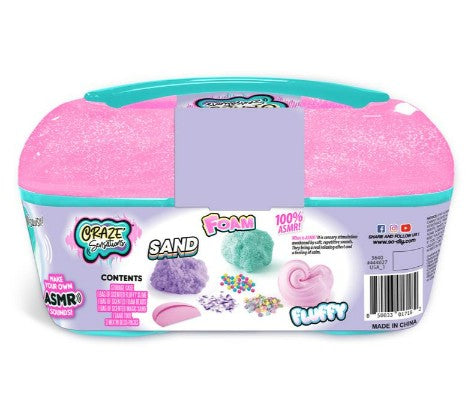 The Craze Sensations ASMR Mixin Sensations Caddy by License 2 Play is a teal and pink plastic container featuring sand, foam, and fluffy slime—ideal for making ASMR sounds and sensory exploration. The packaging displays small images of colorful sand, foam, beads, and pink slime, offering perfect sensory compounds for creative ASMR play.