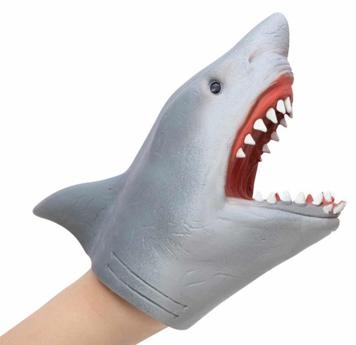 A hand is wearing a gray Schylling Toys Shark Hand Puppet, which features an open mouth displaying sharp teeth and a bright red interior. Ideal for pretend play or puppet shows, this cartoon-like shark puppet brings imaginative stories to life.