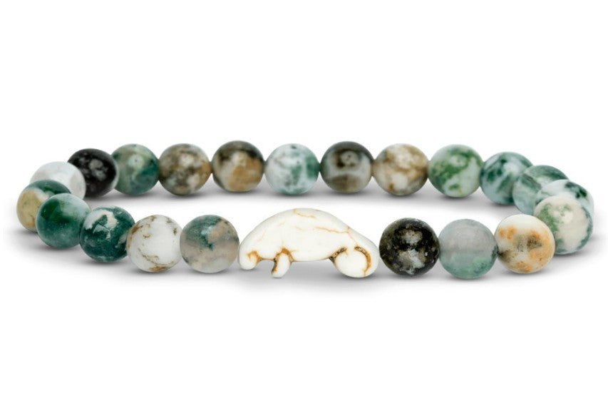 The Drift - Seagrass Green Manatee by fahlo features round green and white marbled beads with a central white bear bead, perfect for nature lovers supporting wildlife conservation—just like wearing a manatee bracelet for preservation.