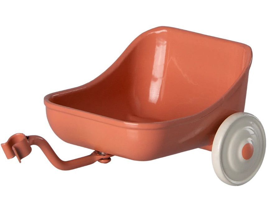 The Maileg Tricycle Hanger, Mouse - Coral by Maileg is a small, coral-colored toy wheelbarrow with a curved handle and white wheel, ideal as mouse accessories or to pair with the Maileg Mouse tricycle, shown against a white background.