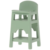 The Maileg High Chair, Mouse - Mint by Maileg is a small, mint green plastic chair with a minimal design, built-in tray, backrest, and open cutouts—perfect for baby mice accessories or as dollhouse furniture.