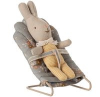 A stuffed bunny in yellow checkered pants and a white collar sits strapped into the Maileg Babysitter, My - Blue by Maileg, a miniature seat perfectly sized for My-sized Maileg mice and friends.