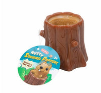 Introducing the Nutty Squirrel Popper by Schylling Toys—a charming brown tree stump-shaped toy with a circular hole at the top, designed as a playful and engaging sensory toy. The attached tag features "Nutty Squirrel Popper" and depicts a cartoon squirrel bursting out of the stump, making it an ideal stress relief and fidget toy for enthusiasts.