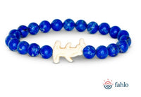 Introducing the fahlo Shark Week - Tidal Wave bracelet: a vibrant blue beaded accessory featuring a white shark-shaped charm at its center, perfect for Shark Week fans. Displayed on a white background with the fahlo logo in the corner, this meaningful bracelet also supports marine conservation through shark tracking initiatives.