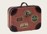 The Maileg Suitcase, Micro - Red by Maileg features a charming red and white checkered pattern, brown corner accents, and whimsical travel stickers from destinations such as Paris, New York, and Camembert—ideal for pretend play adventures or packing essentials for imaginative miniature journeys.