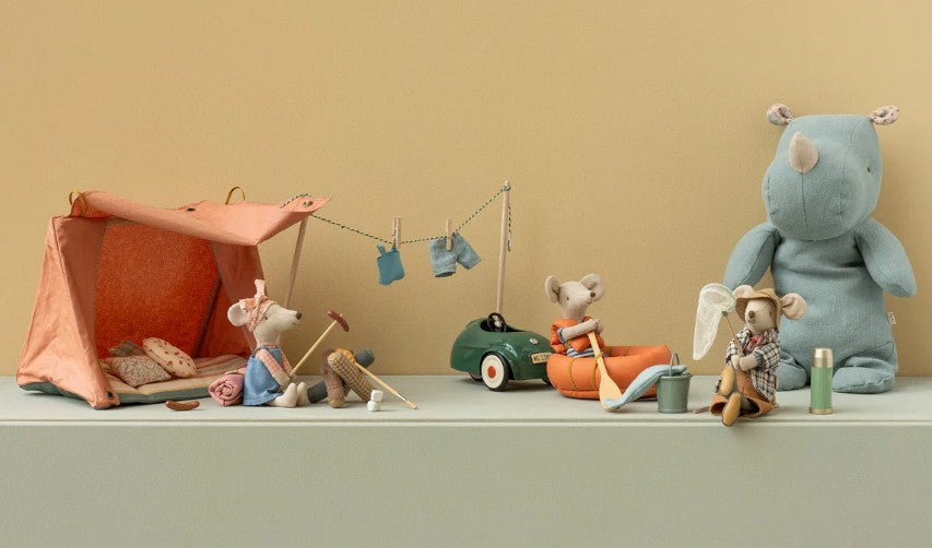 A Maileg Mouse camp scene features the Maileg Fishing Set, Mouse, with a tent, clothesline, canoe, fishing gear, net, and a large blue rhino plush against a beige background.