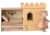 Maileg Princess And The Pea, Big Sister Mouse by Maileg features a mouse in a pink dress beside a cardboard castle and box with stacked mattresses and pillow—a magical fairytale toy inspired by The Princess and the Pea.