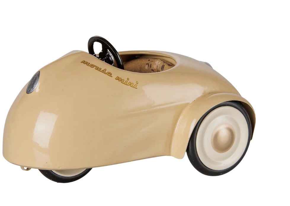 A small, wheat-colored Maileg Car, Mouse features white wheels and a black steering wheel with “Moneta mini” written on the hood. This Maileg car showcases a minimalist, vintage design that’s perfect for miniature car collections and imaginative play.