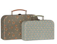 Two vintage-inspired Maileg suitcases with handles—including one larger case featuring a brown floral pattern and one smaller case adorned with a blue and beige geometric design—stand side by side against a white background. Perfect as the charming Maileg Suitcase set, 2 pcs - Michette for pretend play or as collectible pieces from Maileg.
