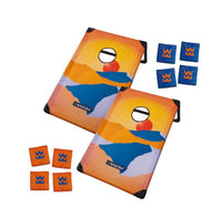 The Waboba Corn Hole Travel Set by Waboba includes two vibrant, portable boards featuring abstract mountain and sun artwork, along with eight bean bags—four orange and four blue—each displaying a W logo, making it the perfect on-the-go game for fun wherever you travel.