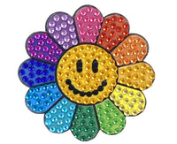 At the center of the StickerBean Rainbow Daisy sticker by StickerBean is a smiling face, surrounded by rainbow-colored petals adorned with shiny, gem-like beads for a cheerful and vibrant design.