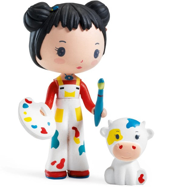 DJECO Tinyly Barbouille & Gribs by DJECO features a charming collectible figure of Barbouille, a girl with black hair in buns, holding a paint palette and brush and dressed in paint-splattered overalls, alongside her colorful companion Gribs the white cow. Perfect for imaginative play or expanding your Tinyly figure collection.