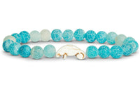 The fahlo Drift - Aqua Blue Manatee bracelet features round crackled turquoise-blue beads and a single white manatee-shaped bead—perfect for wildlife conservation enthusiasts.