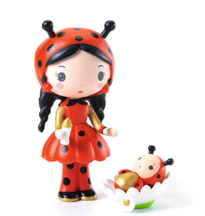 The DJECO Tinyly Coco & Minico figurine from DJECO features Coco dressed in a red and black ladybug costume holding a baby bottle, standing next to Minico, an adorable baby in a matching ladybug outfit nestled in a white flower. Ideal for collectors and imaginative play, this charming figure brings enchantment to any display.