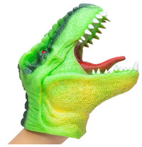A person's hand is inside the Schylling Toys Dinosaur Hand Puppet, which features a green design with an open mouth displaying white teeth and a red tongue—perfect for imaginative play and storytelling.