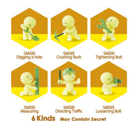 Six yellow Smiski Construction Series figurines from Dreams USA each tackle a different construction task: digging, crushing rock, tightening a bolt, measuring, directing traffic with a helmet, and loosening a bolt—each activity labeled with text. These glow-in-the-dark collectible blind-box figurines come in six types (plus the chance for a secret one), all displayed at the bottom.
