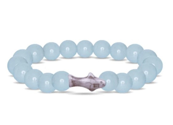 The fahlo Voyage - Aqua Glow Shark bracelet features round, light blue beads and a central silver fish-shaped bead, inspired by shark bracelets—perfect for ocean lovers.