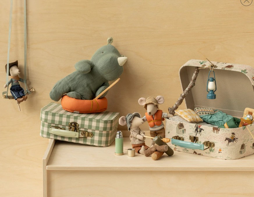 Maileg’s Hiker Mouse, Big Brother - Thin Stripes, is displayed on a wooden shelf with suitcases, a lantern, cushion, and fun camping-themed Maileg accessories against a simple backdrop.