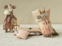 Maileg's Princess And The Pea, Big Sister Mouse features a charming mouse dressed in patterned clothes, resting on blankets with a green pea beneath—a whimsical tribute to the classic fairy tale.