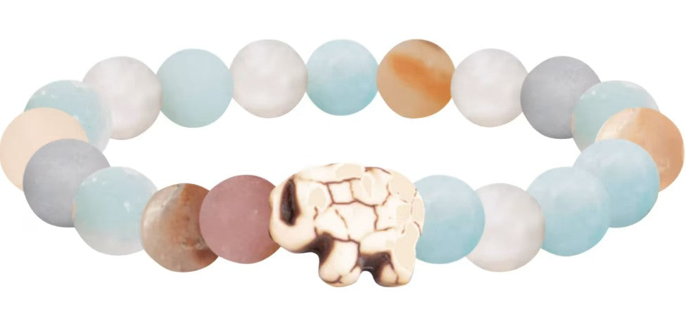 The Expedition - Sky Stone Elephant bracelet by fahlo features pastel blue, white, tan, and pink beads with a cream elephant centerpiece—a perfect accessory for anyone who loves elephant conservation.
