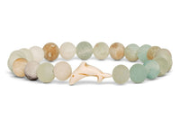 The Odyssey - Sky Stone Dolphin bracelet by fahlo features frosted pastel beads and a central white dolphin charm—a stylish accessory that subtly supports marine conservation.
