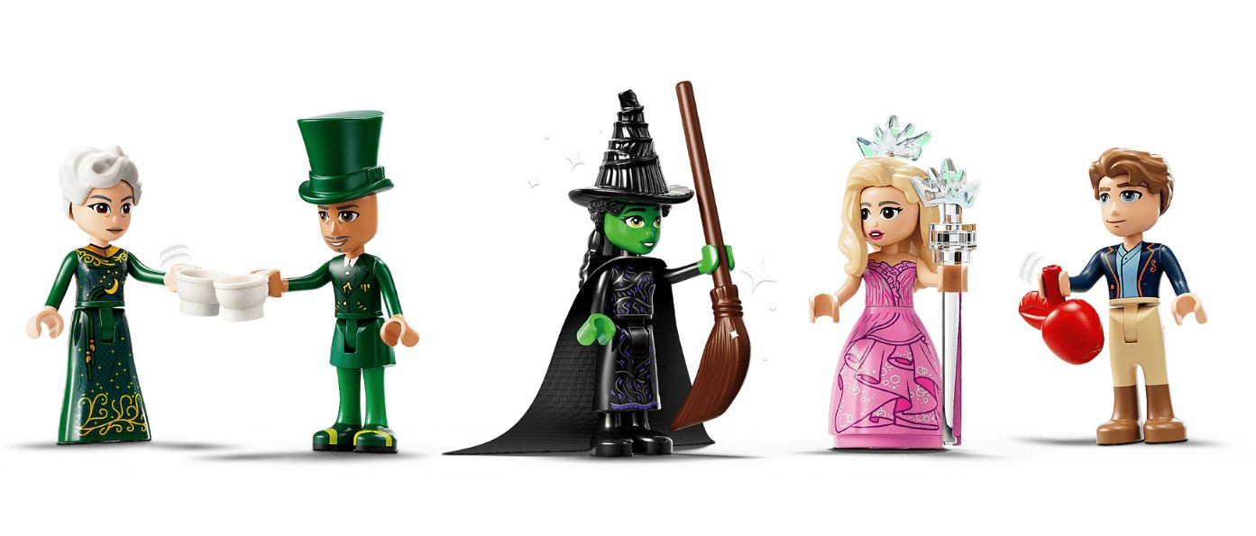 Five LEGO minifigures dressed as characters from Wicked, including a green witch, stand in a line with props like a broom, teacups, and heart—an enchanting play-and-display set from the LEGO Wicked Welcome to Emerald City collection.