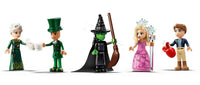 Five LEGO minifigures dressed as characters from Wicked, including a green witch, stand in a line with props like a broom, teacups, and heart—an enchanting play-and-display set from the LEGO Wicked Welcome to Emerald City collection.