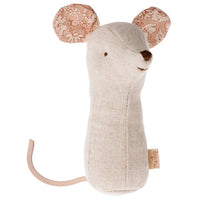 The Maileg Lullaby Friends Mouse Rattle - Nature by Maileg features soft beige plush, embroidered eyes, a brown nose, patterned pink ears, and a long tail. Minimalist and gentle—ideal as a sensory comfort toy for babies.