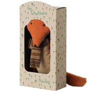 The Maileg Fox, Big Brother by Maileg features a charming stuffed fox with a brown scarf, sitting in a windowed cardboard box adorned with small green trees and labeled for Brothers. Perfect for imaginative play, the fox’s orange face and tail are visible through the package window.