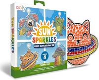 The Ooly Sun Sparkles: Gem Suncatcher Kit – Cosmic Fun features a vibrant box decorated with designs of a rocket, alien, UFO, and cat. This enjoyable craft kit comes with one finished orange cat suncatcher adorned with sparkling gems and beads, making it perfect for creating celestial or space-themed window art. Suitable for ages 6 and up.