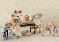 Maileg’s Baby Mouse in Gown - Powder joins five other charming Maileg mice around a table with a tall cake, while the baby mouse enjoys pastries and a drink nearby—a cozy, vintage-inspired scene perfect for nurturing play.