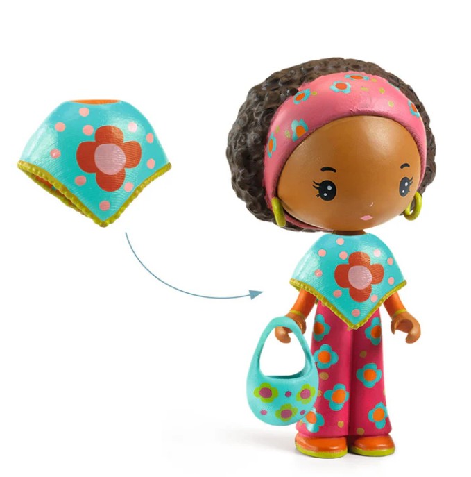 Meet DJECO Tinyly Poppy & Nouky—a charming collectible figure from DJECO featuring Poppy, a figurine with brown skin and curly brown hair dressed in a pink outfit decorated with blue and orange flower patterns, yellow earrings, a coordinating blue purse, and a removable blue cape adorned with flowers. Perfect for imaginative play or adding to your Tinyly collection!.