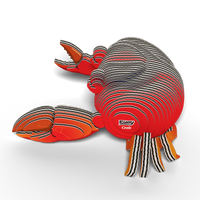 A EUGY Crab 3D Puzzle by Eugy, made from eco-friendly interlocking red, orange, and black cardboard pieces, sits on a white background. This puzzle features two large claws, striped legs, and has "Crab" printed on the side.