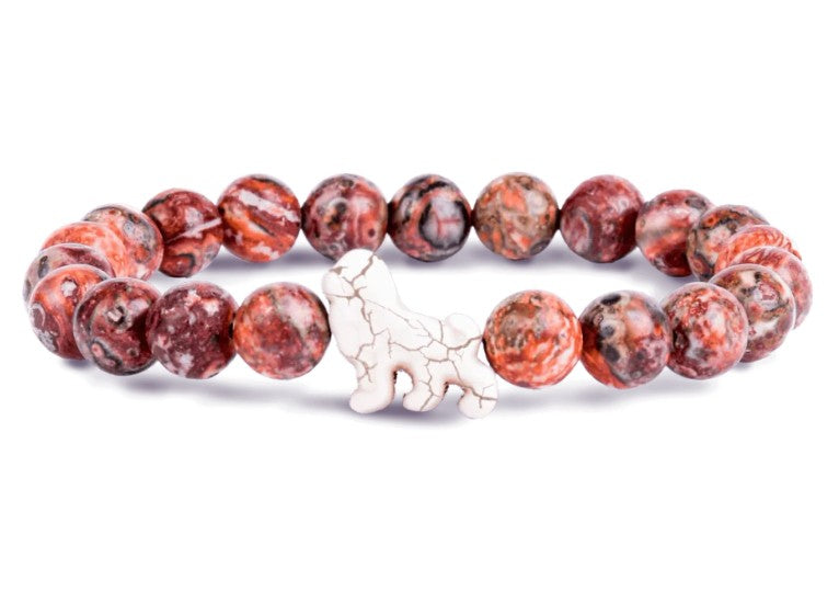 The Excursion - Sahara Stone Lion bracelet by fahlo features round, marbled red and brown stones with a white lion charm—ideal for supporting wildlife conservation or tracking animals.