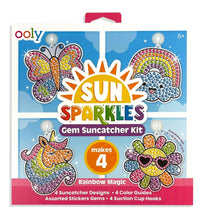 The Ooly Sun Sparkles: Gem Suncatcher Kit - Rainbow Magic box showcases vibrant gem designs—including a butterfly, rainbow, unicorn, and flower—and states that it creates 4 sparkling suncatchers. The kit comes with gems, guides, and suction cup hooks for a complete window art craft experience.